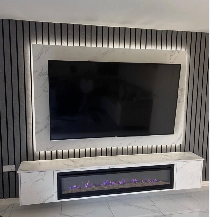 Charcoal slat TV wall with a backlit white marble surround and a linear fire in the floating console