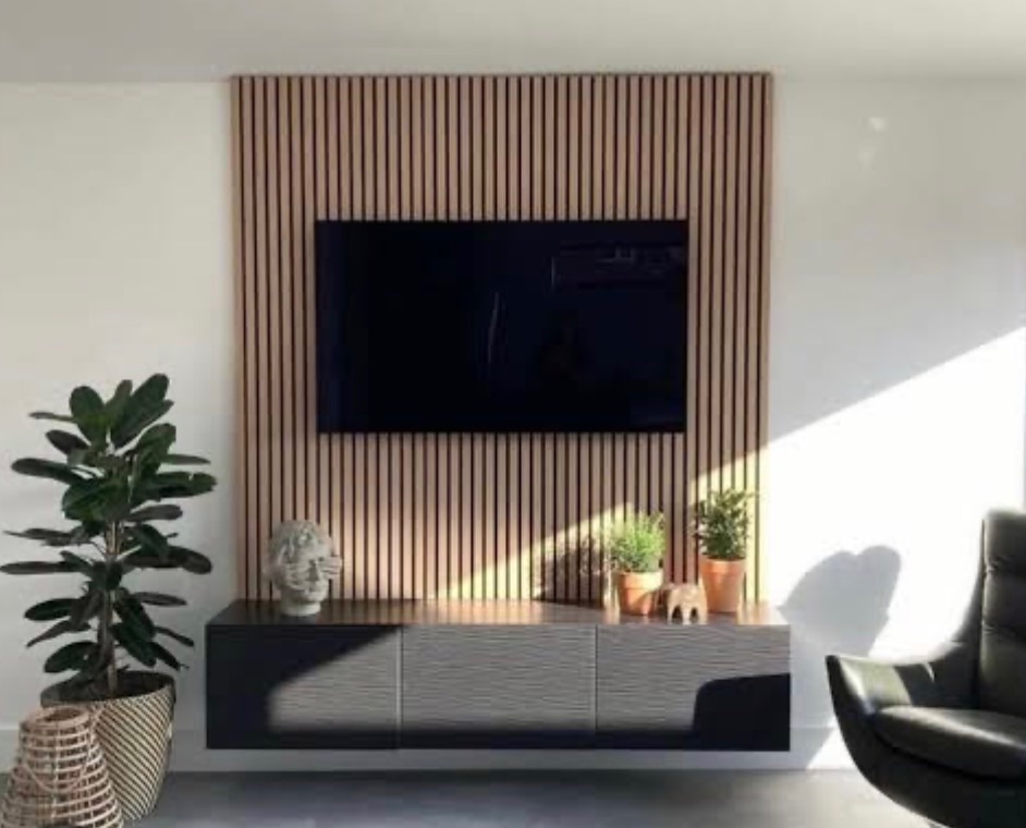 Oak slat panel behind a wall-mounted television with a dark floating console